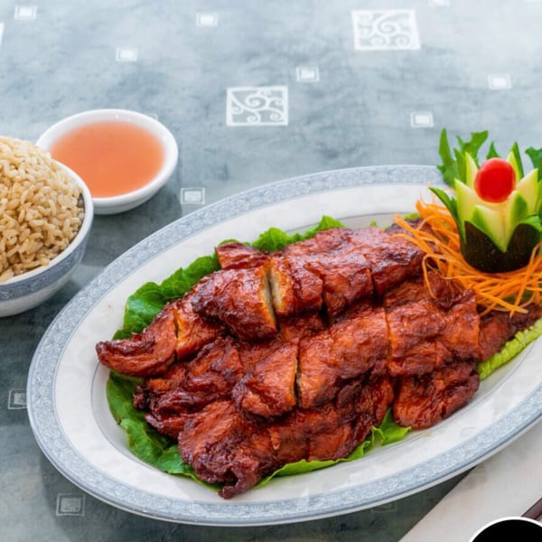 Vegetarian BBQ "pork" slices on lettuce, with a side of brown rice and sweet and sour sauce.