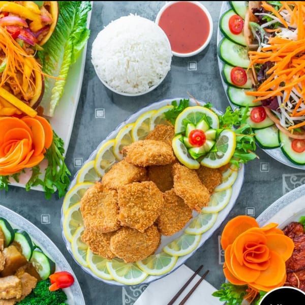 A top-down view of various vegetarian dishes, including fried cutlets, rice, and salads.