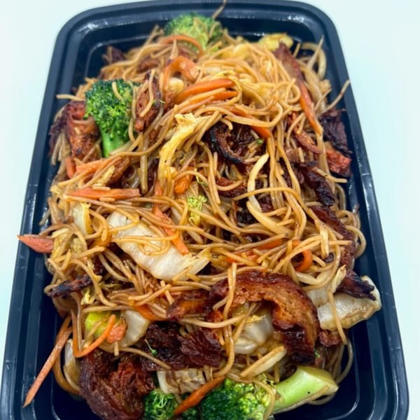 Vegetarian chow mein with noodles, broccoli, carrots, and plant-based protein in a black takeout container.